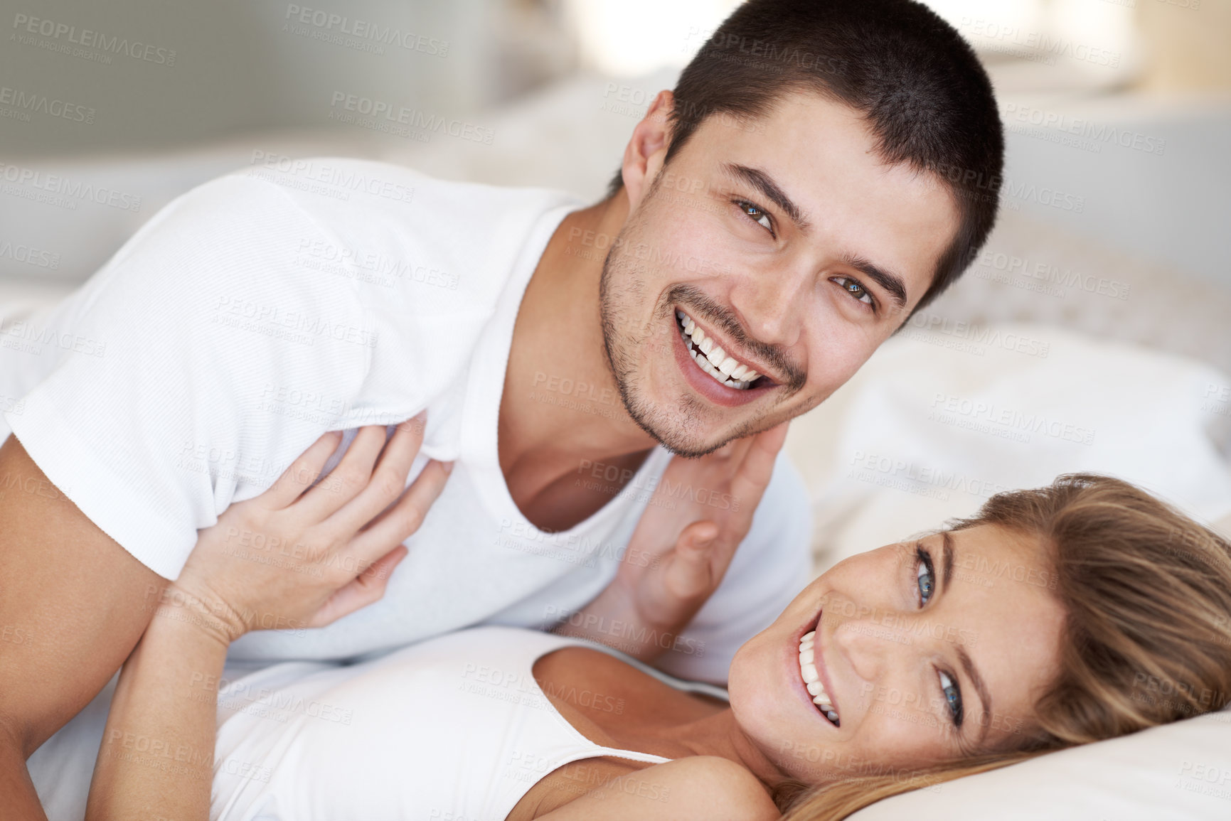 Buy stock photo Romance, woman and man in bed with portrait, smile and relax together for holiday comfort in home. Rest, love and happy couple in bedroom on weekend morning with wake up, care and rest in apartment