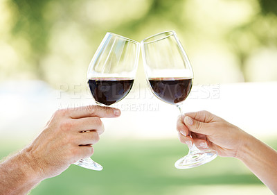 Buy stock photo Cropped view of a couple's hands toasting with two glasses of wine