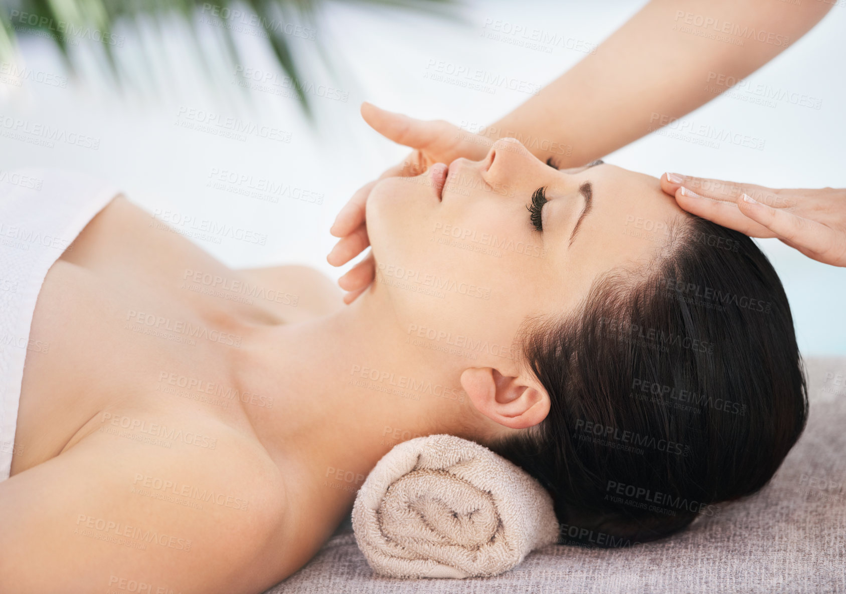 Buy stock photo A young woman getting a face massage from a massage therapist
