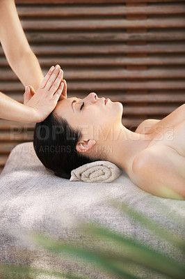 Buy stock photo A young woman getting a face massage from a massage therapist