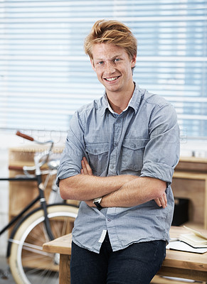 Buy stock photo Portrait of a good-looking joyful male in casual wear standing near the table with crossed hands and looking at the camera.
A happy young caucasian boy standing with a smile on an office campus.