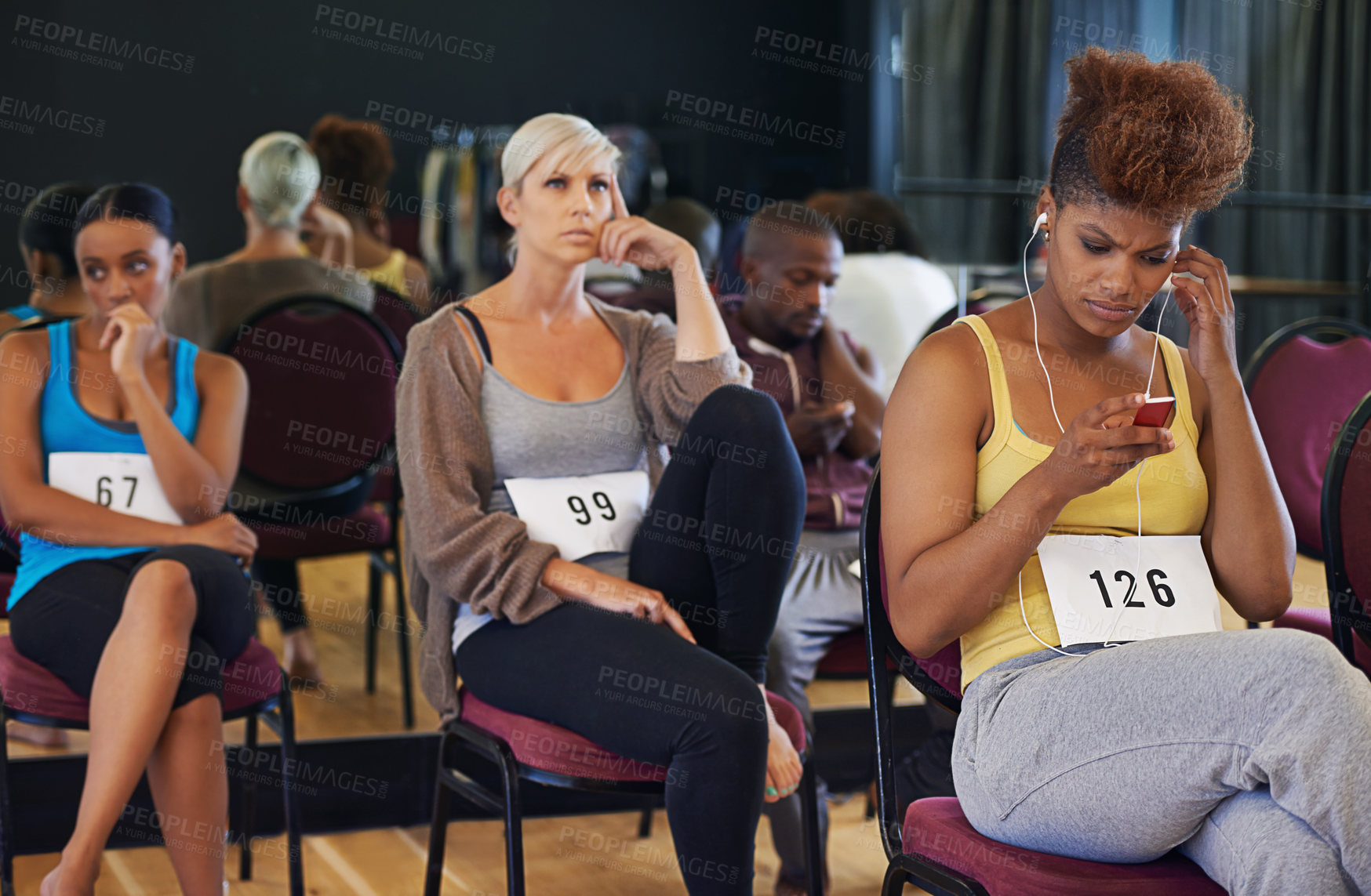 Buy stock photo Shot of a group of young dancers looking anxious while waiting for their dance auditions