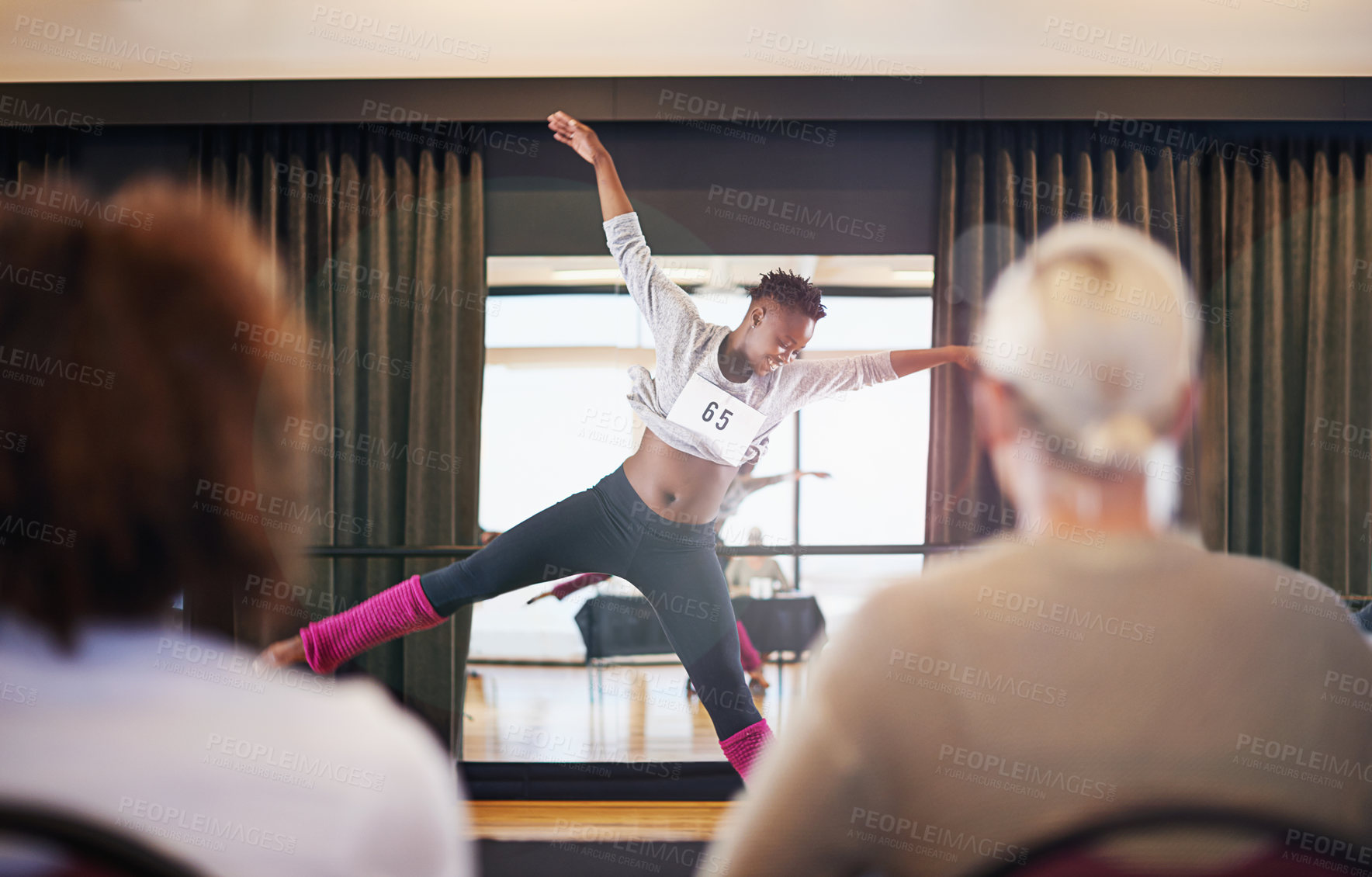 Buy stock photo Shot of a female dancer performing before the judges during a dance audition
