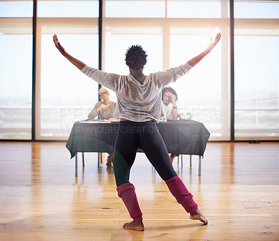Buy stock photo Rearview shot of a female dancer performing before the judges during a dance audition