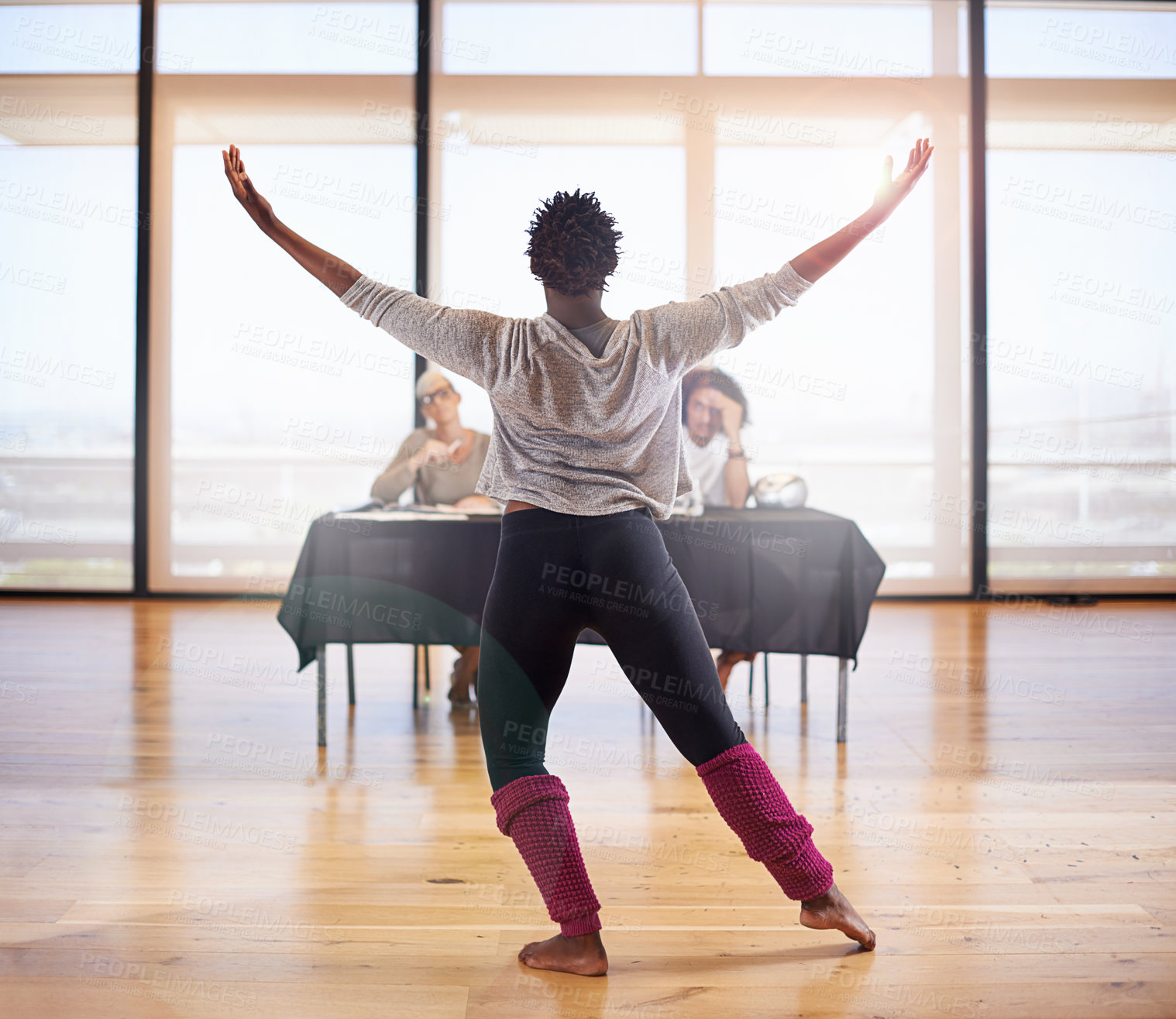 Buy stock photo Rearview shot of a female dancer performing before the judges during a dance audition