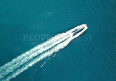 Buy stock photo High angle shot of a boat speeding through the water