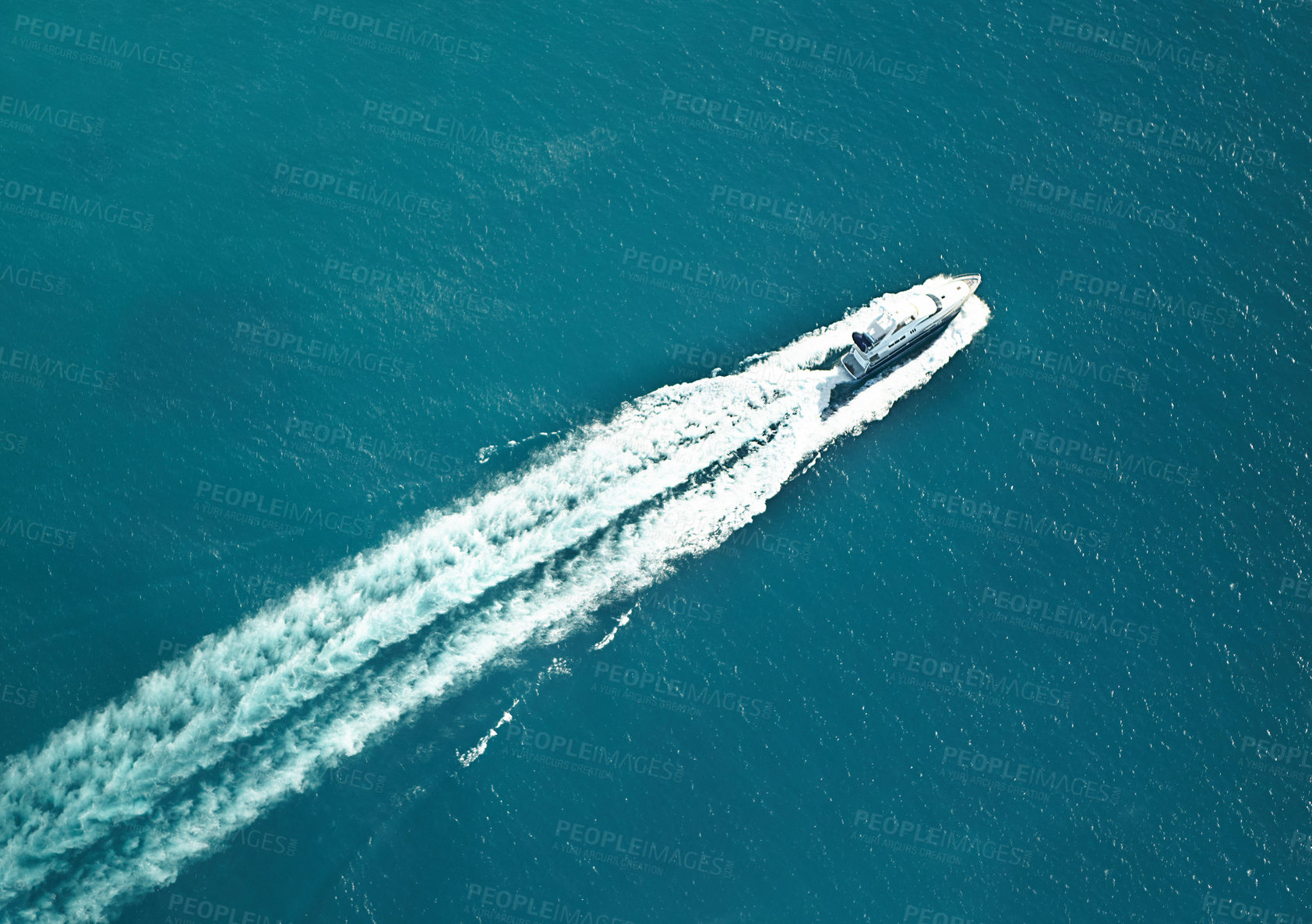 Buy stock photo High angle shot of a boat speeding through the water