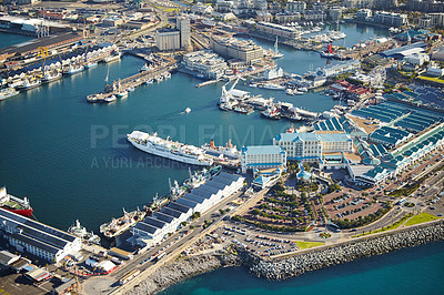 Buy stock photo Harbor, drone and buildings by dock in ocean for travel with cargo ships or cruise in city. Infrastructure, coast and aerial view of boats at shore by sea water for holiday destination in Cape Town.