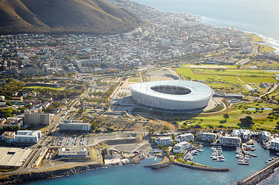 Buy stock photo Harbor, drone and stadium in city for travel with ships, cruise or buildings by ocean and mountain. Boats, coast and aerial view of infrastructure by seashore for holiday destination in Cape Town.