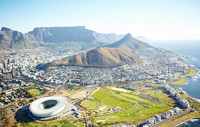 Buy stock photo Mountain, buildings and drone of landscape in nature for travel destination in city with blue sky. Infrastructure, stadium and aerial view of scenic green environment by sea for tourism in Cape Town.