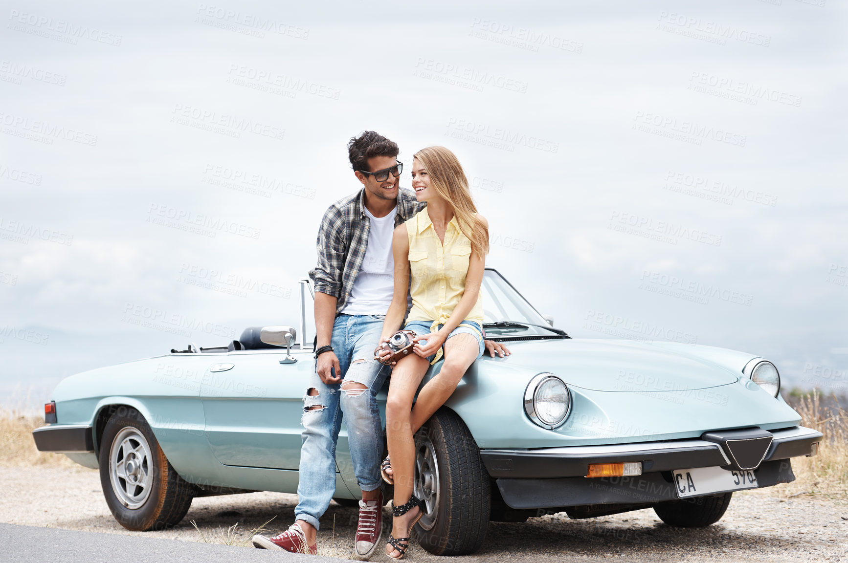 Buy stock photo Road trip, car and couple with camera for photography, holiday journey and happy memory for honeymoon. Outdoor, man and woman by convertible motor with technology for picture and vacation adventure