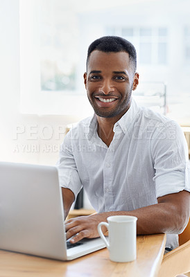 Buy stock photo A handsome young businessman working in an informal office setting