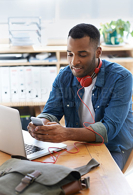 Buy stock photo Happy, creative man and laptop with phone for social media, reading news or online browsing at office. Male person, designer or smile on mobile smartphone for web, internet or connection at workplace