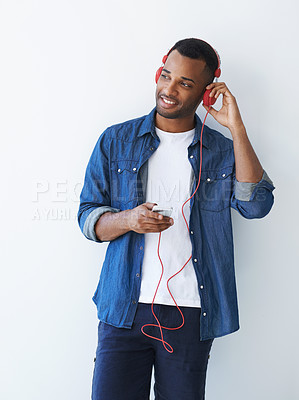 Buy stock photo Black man, smartphone and headphones to listen by wall, idea and choice for streaming by white background. Playlist curator, person or tech for art, mockup space and review with music on mobile app