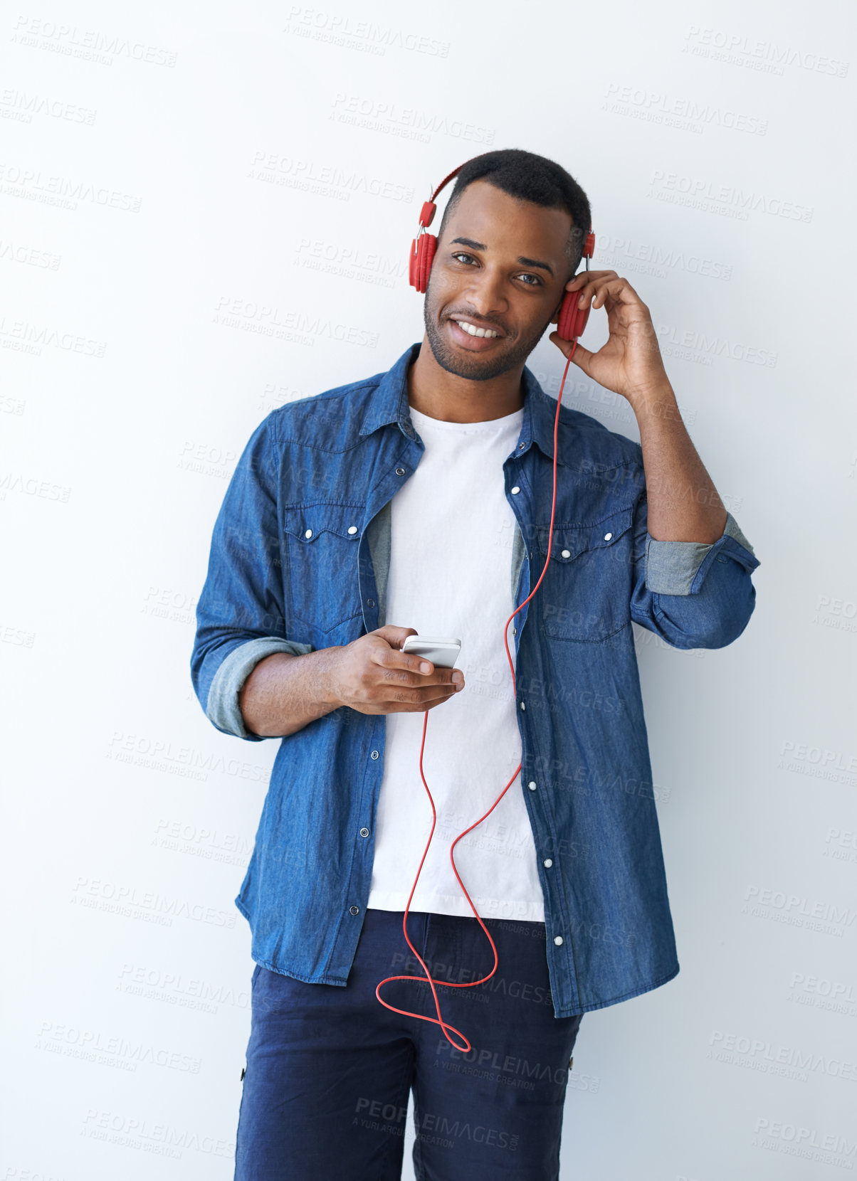 Buy stock photo A young african american man wearing a headphones and listening to music against a white background 