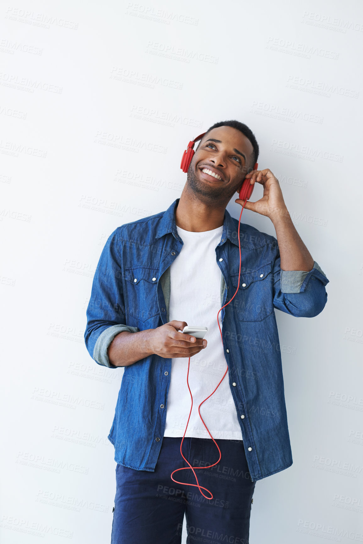 Buy stock photo A young african american man wearing a headphones and listening to music against a white background 