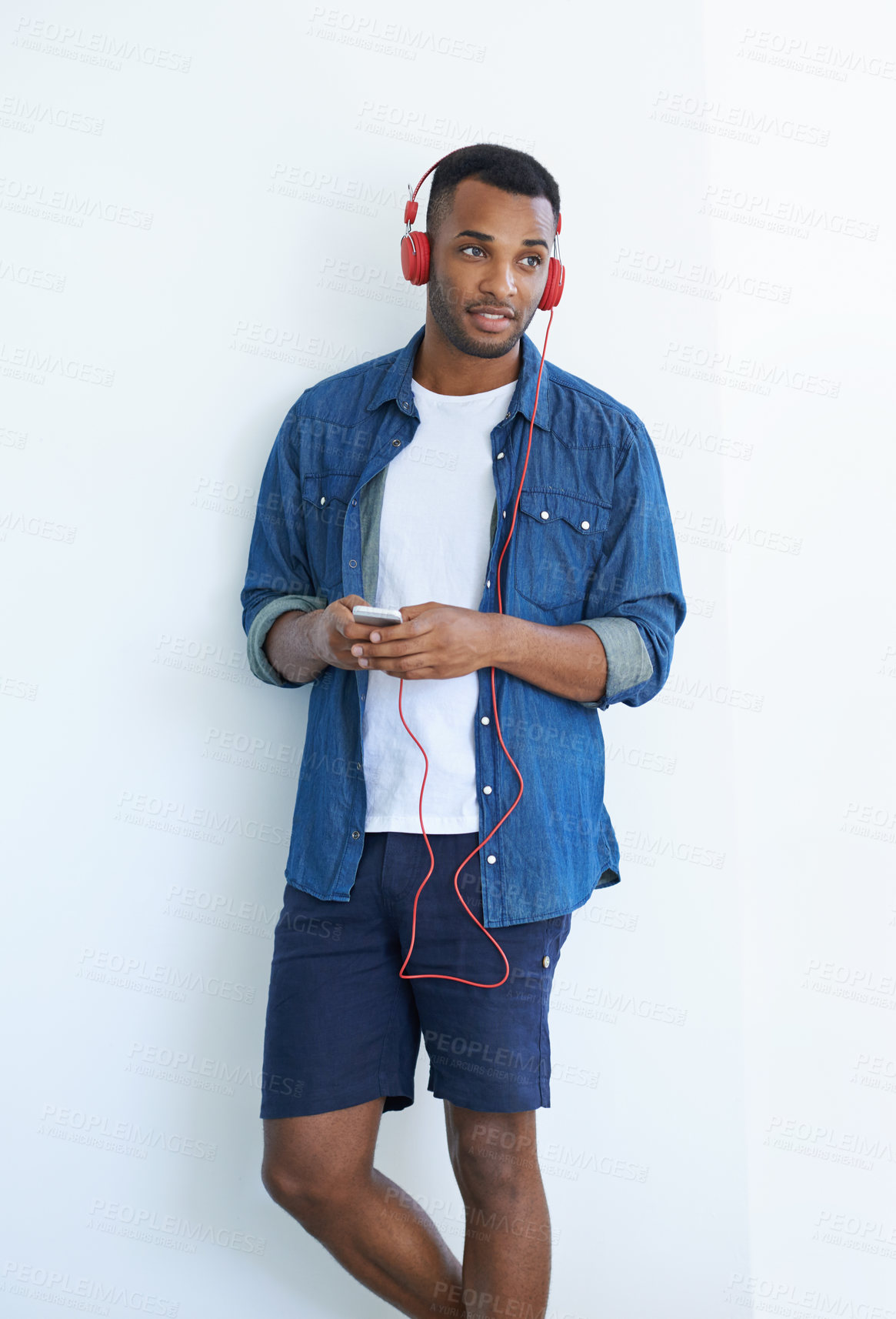 Buy stock photo A young african american man wearing a headphones and listening to music against a white background 