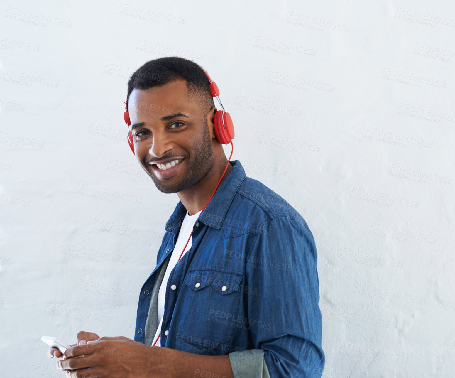 Buy stock photo A young african american man wearing a headphones and listening to music against a white background 