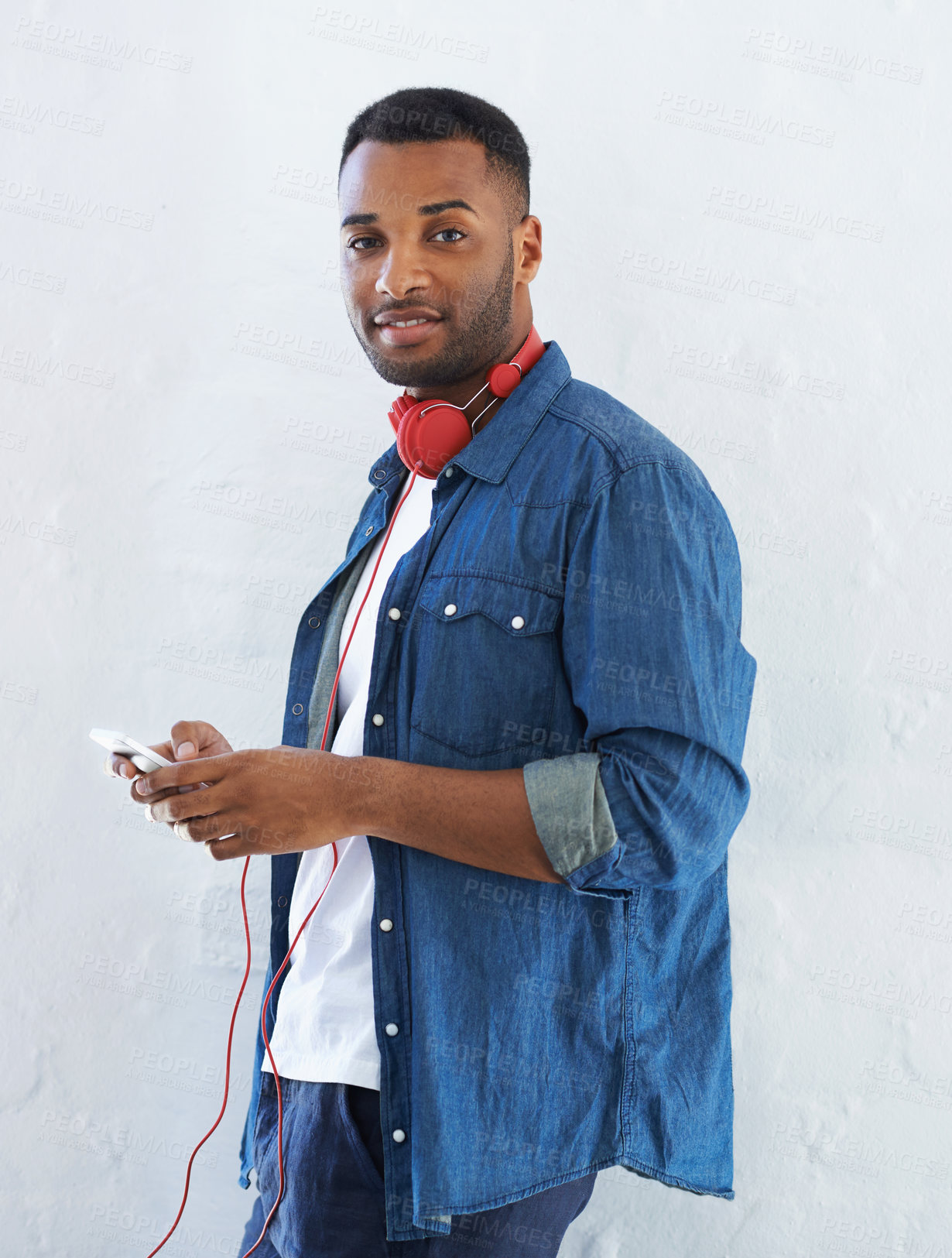 Buy stock photo Black man, portrait and headphones with phone for music, podcast or audio on a wall background. Young African or male person with smile or headset on mobile smartphone for radio, listening or sound