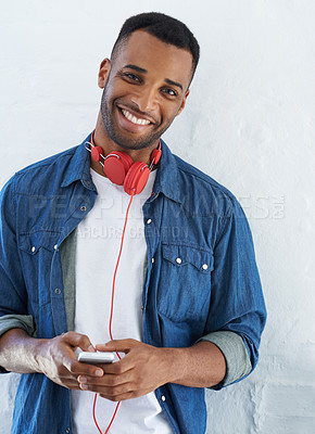 Buy stock photo A casual young african american man with his headphones around his neck while against a white background