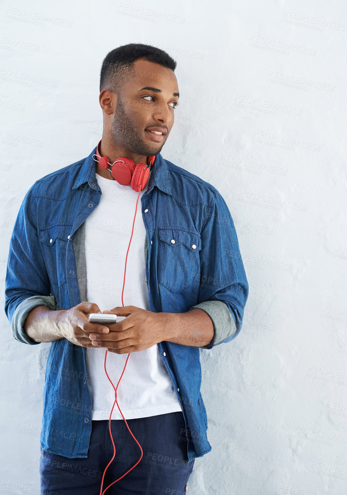 Buy stock photo Headphones, black man and wall for music and relax, audio and podcast for streaming on cellphone. Technology, online radio and mobile app for thinking and break, student and internet for male person