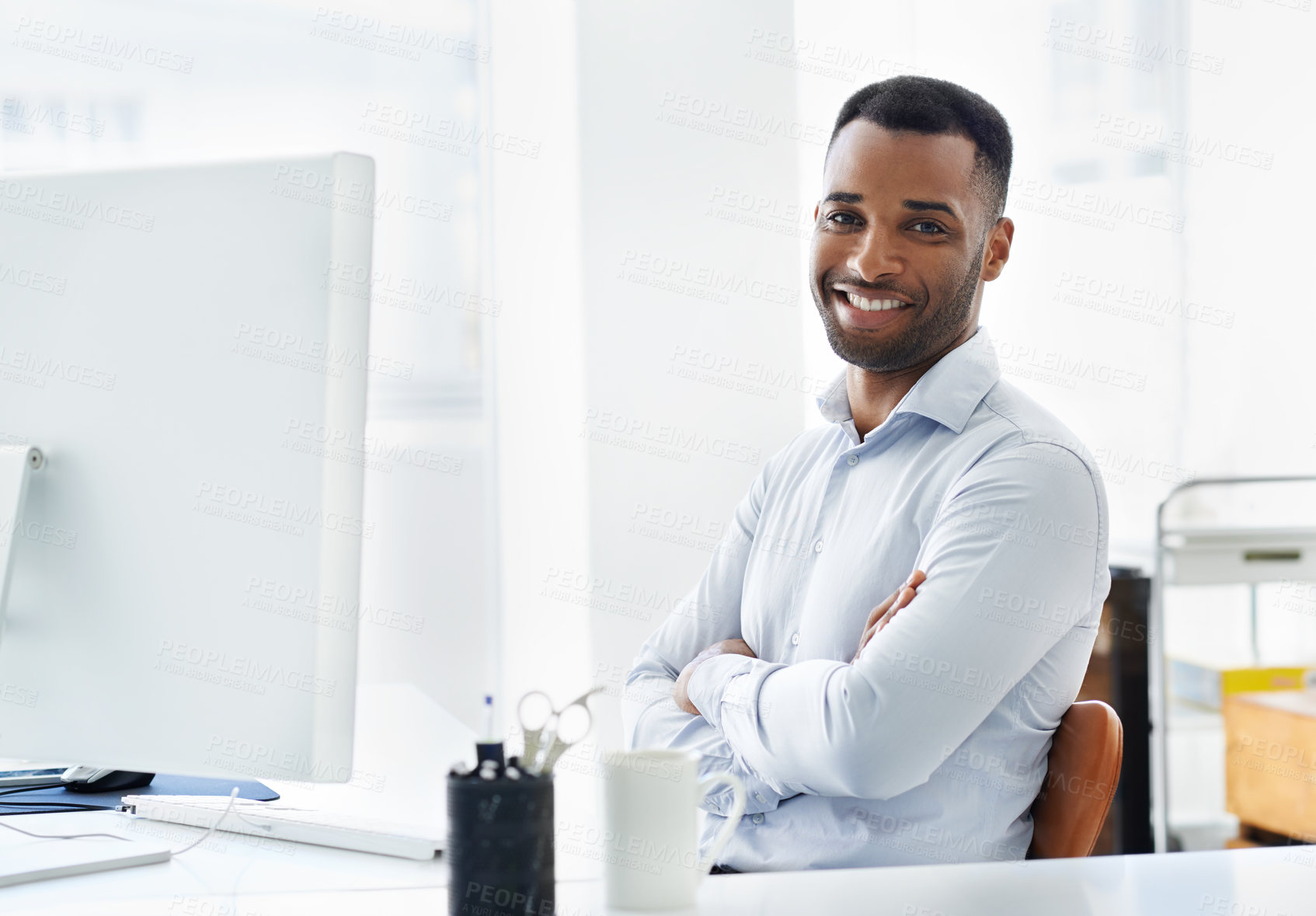 Buy stock photo A handsome young african american businessman working at his desk