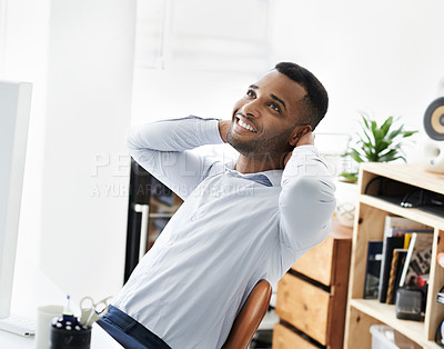 Buy stock photo A handsome young african american businessman sitting at his desk and relaxing