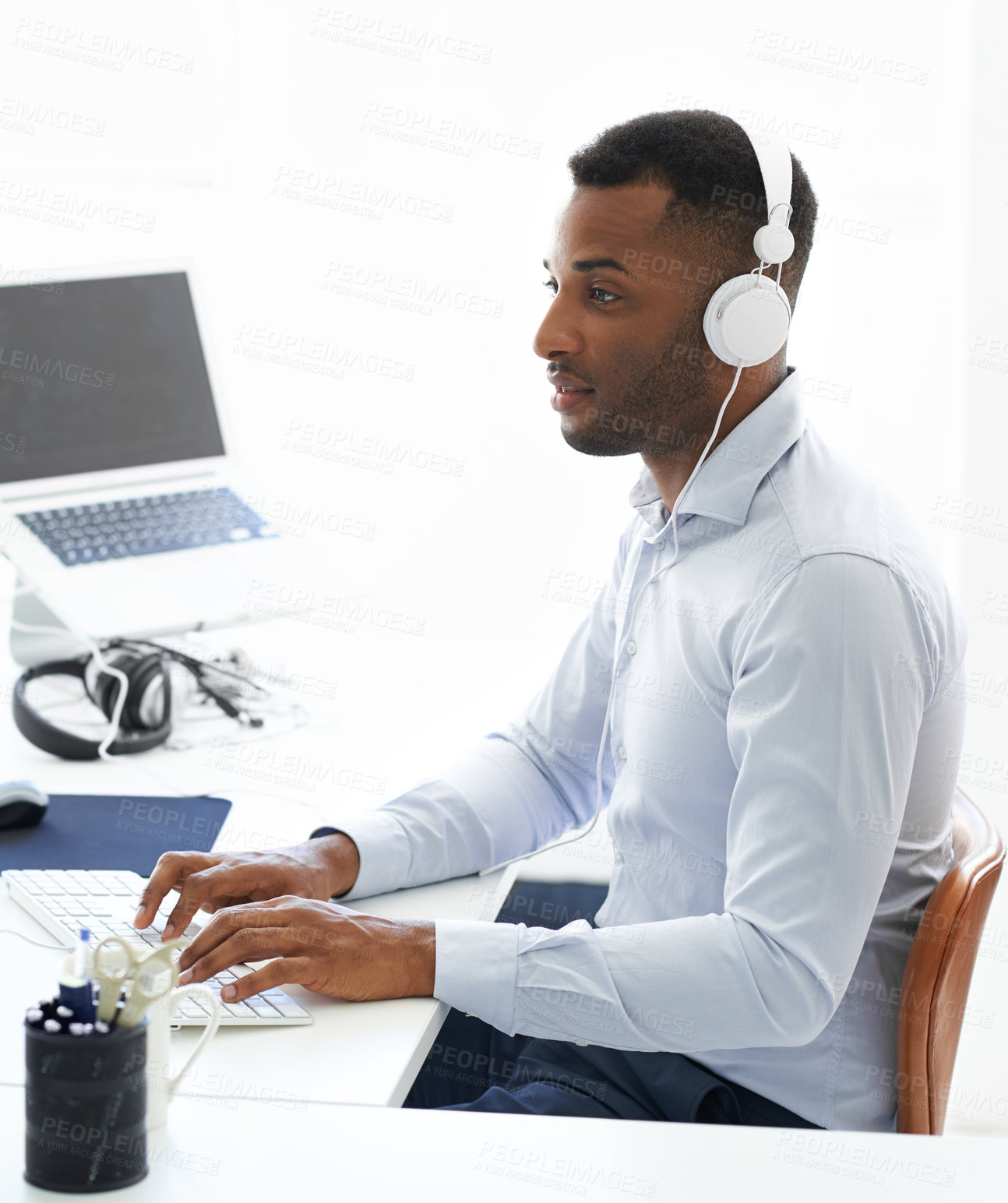 Buy stock photo Black man, computer and music for working at desk, online and streaming audio on office internet. Male person, cloud computing and feedback for html code, programming and headphones for podcast