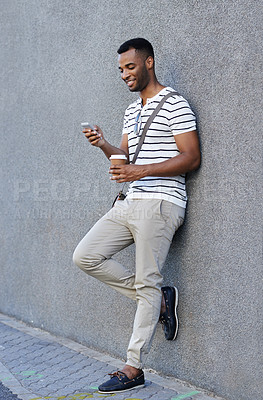 Buy stock photo Black man, coffee and phone in city for travel, social media and scroll online in outdoor. Male person, typing and app for communication in town by wall, chat and beverage for commute or email