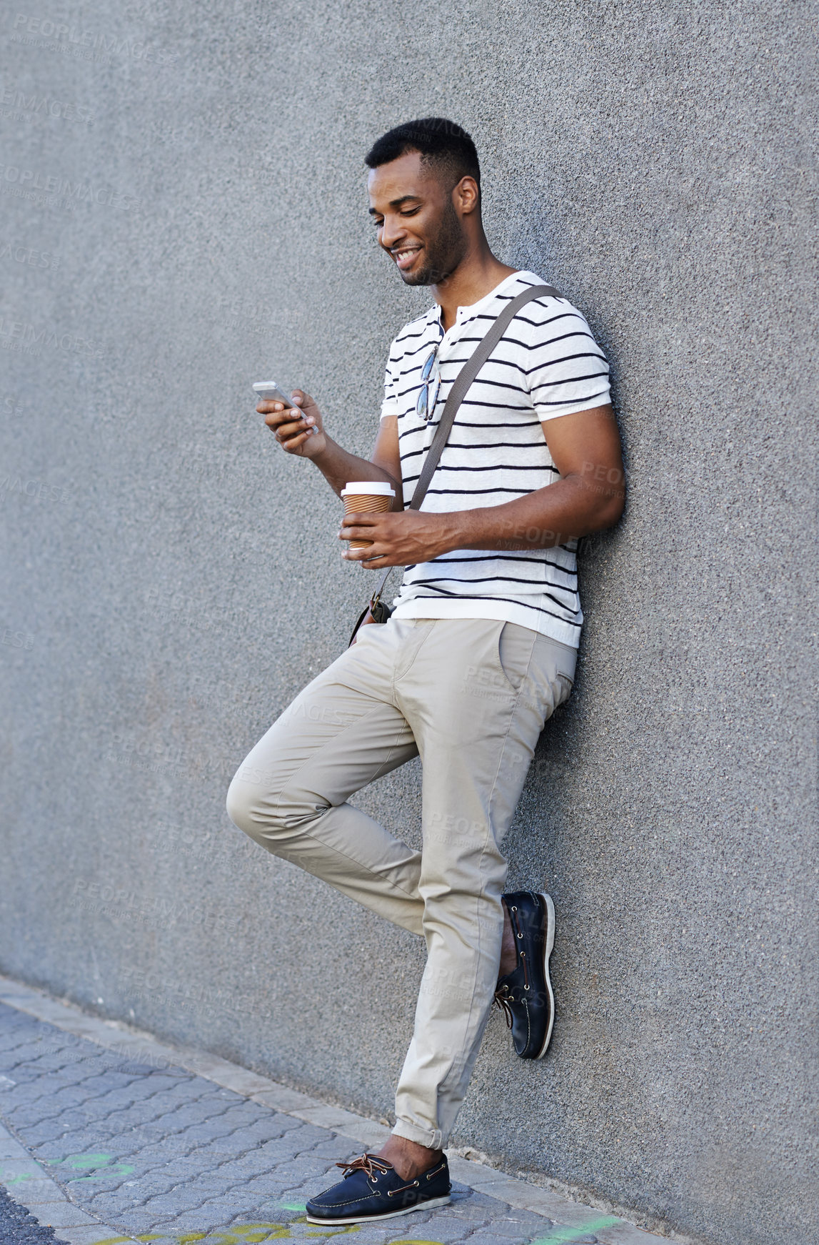 Buy stock photo Black man, coffee and phone in city for travel, social media and scroll online in outdoor. Male person, typing and app for communication in town by wall, chat and beverage for commute or email