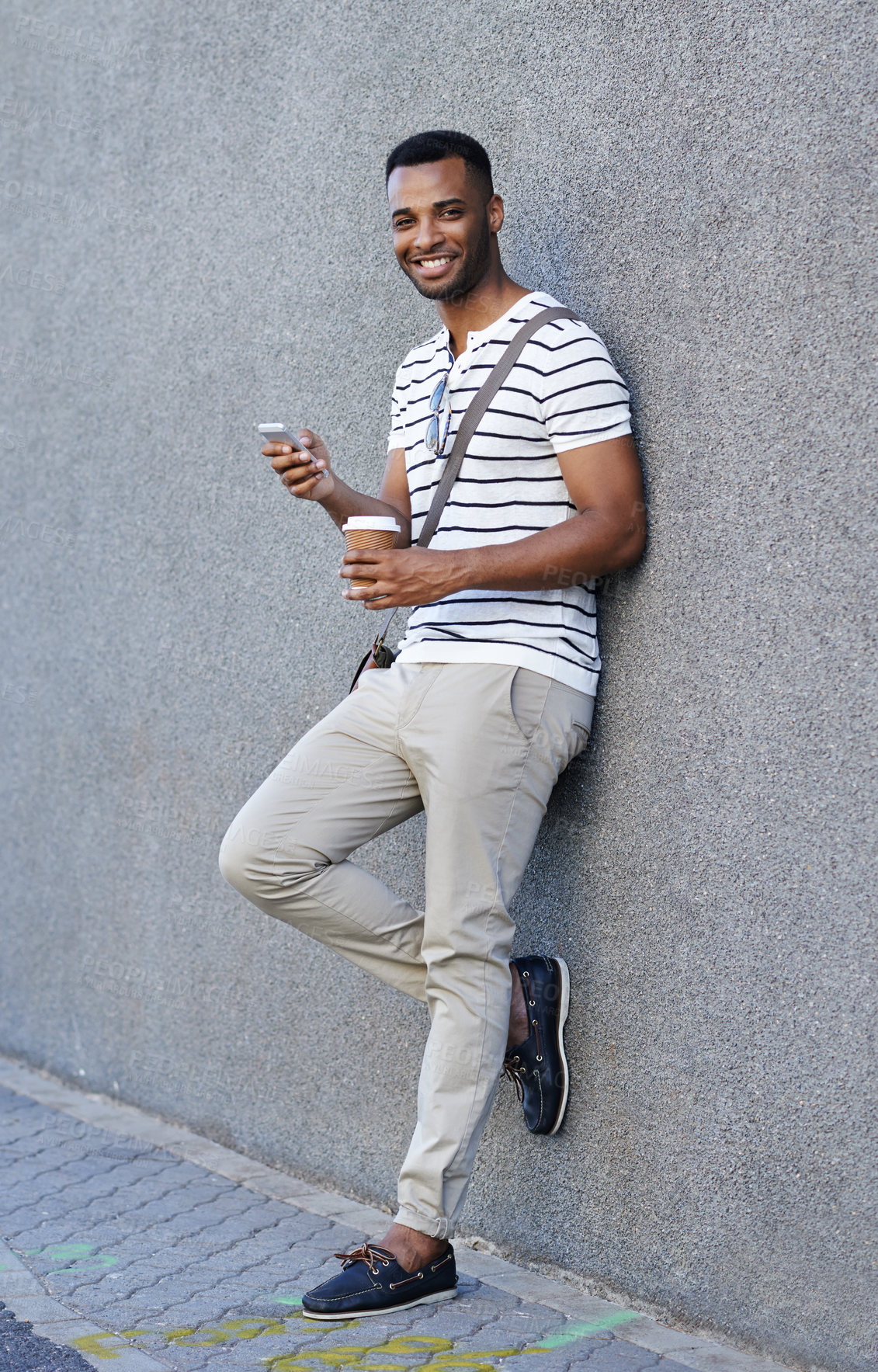 Buy stock photo Portrait, black man and happy with smartphone or coffee for work break on social media in New York. Male person, smile and confident or satisfied with networking or communication on against the wall