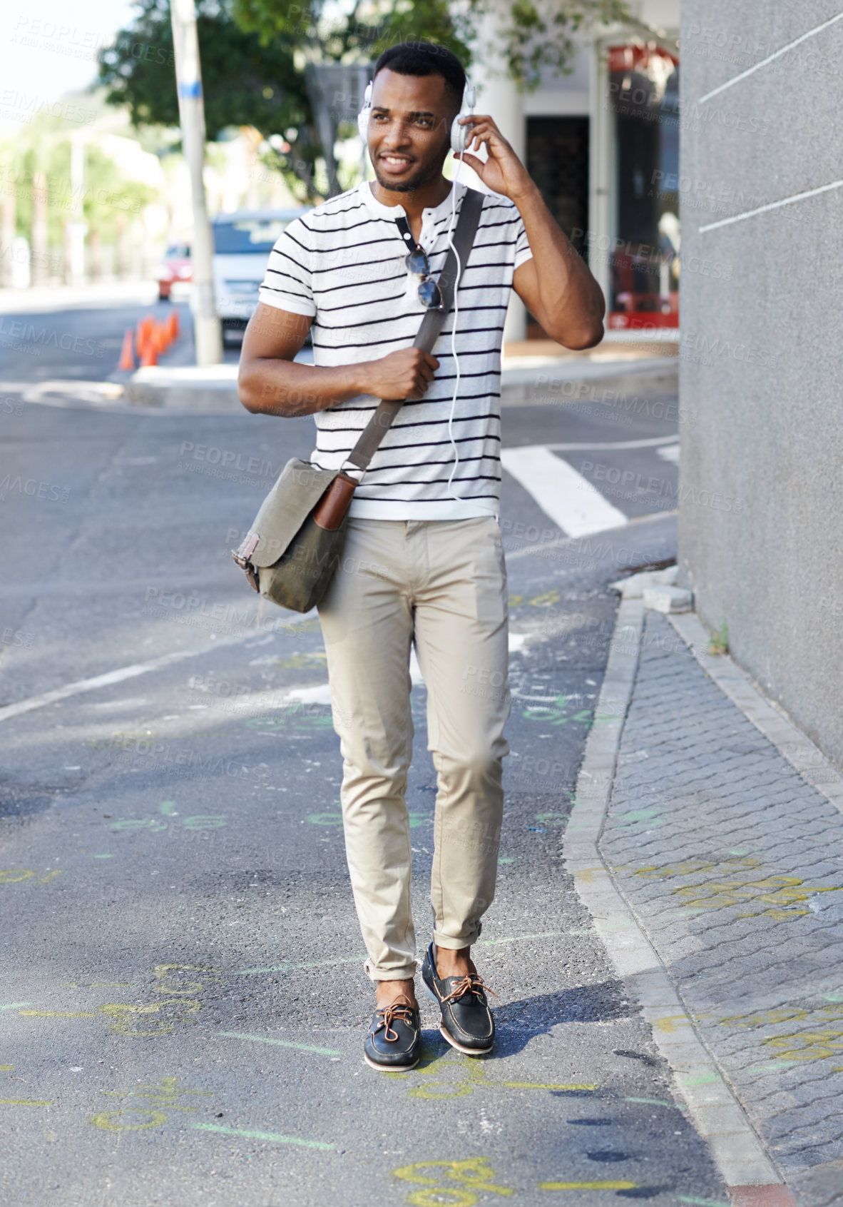 Buy stock photo Black man, headphones and student for street commute, walking and listening to music in city. Male person, hearing audio and streaming sound on journey to college, travel and podcast in urban town