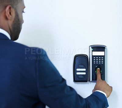 Buy stock photo A cropped rear view of a young african american businessman scanning his finger to gain entry to a building