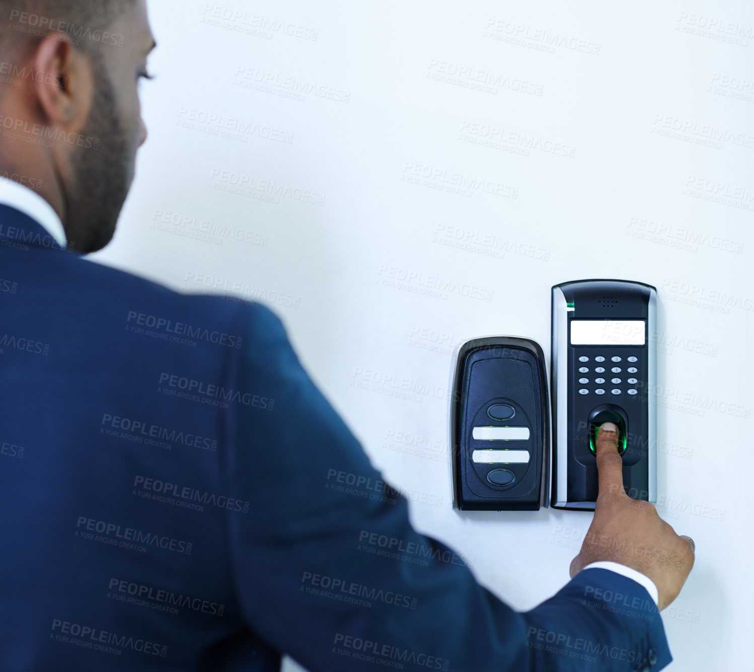 Buy stock photo A cropped rear view of a young african american businessman scanning his finger to gain entry to a building