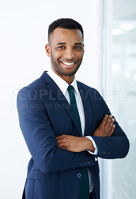 Buy stock photo A handsome young african american businessman standing indoors with his arms folded