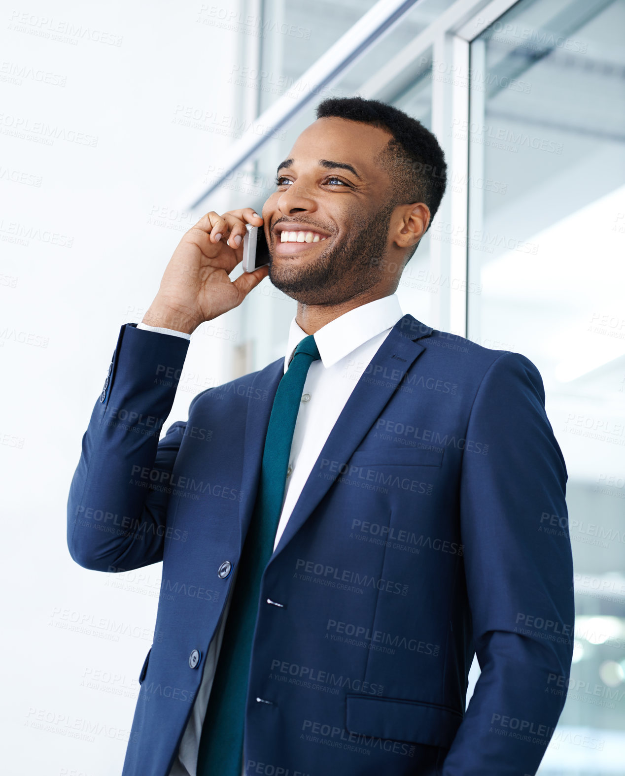 Buy stock photo A handsome african american businessman using his smartphone while indoors