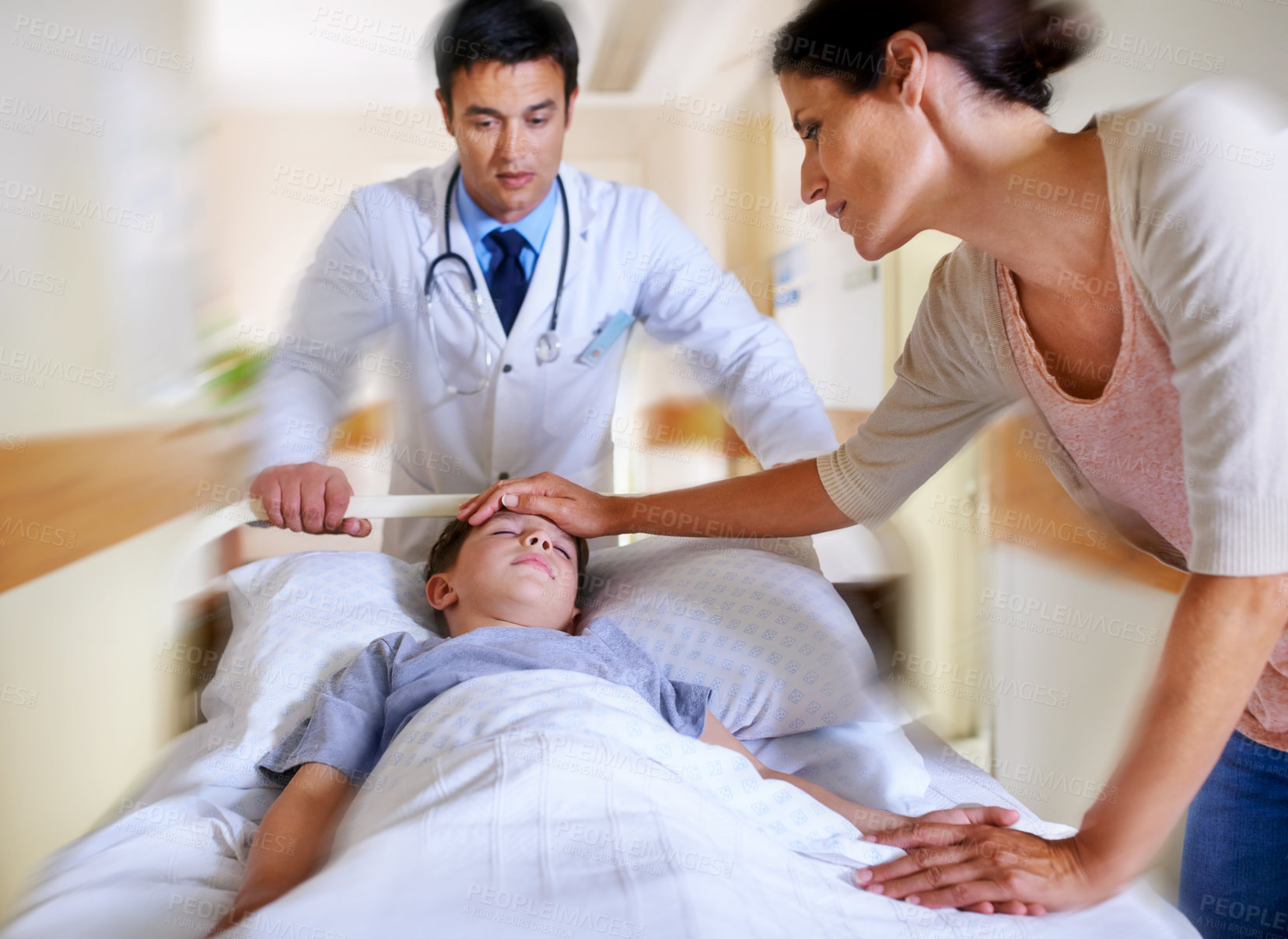 Buy stock photo Cropped shot of a patient being wheeled away by his doctor and mother