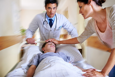 Buy stock photo Shot of a mother feeling her son's tempreture as he is wheeled away by the doctor