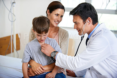 Buy stock photo Shot of a caring doctor examining his young patient