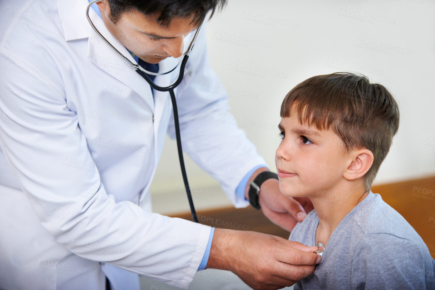 Buy stock photo Cropped shot of a doctor listening to his patient's heartbeat