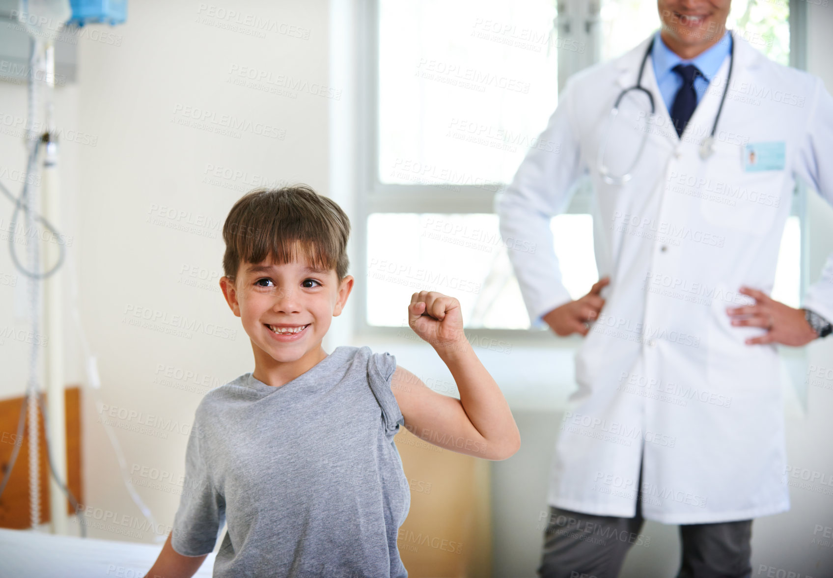 Buy stock photo Doctor, young and happy strong boy in hospital for health, wellness and success with flexing arm. Pediatrician, exam and child with smile in clinic for healthcare, medicine and medical results