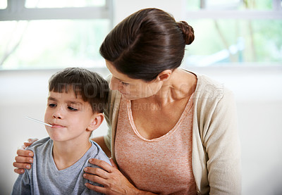 Buy stock photo Cropped shot of a concerned mother watching her son's tempreture being taken