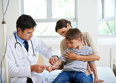 Buy stock photo Shot of a doctor placing an IV in his young patient's hand