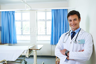 Buy stock photo Portrait of a handsome young doctor standing in a hospital ward