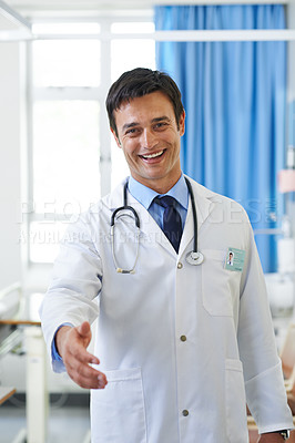 Buy stock photo Portrait of a handsome young doctor extending his hand in greeting
