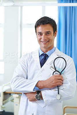 Buy stock photo Portrait of a handsome young doctor holding a patient chart and a stethoscope