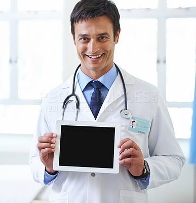 Buy stock photo Portrait of a handsome young doctor holding up a tablet so that the screen is facing the camera
