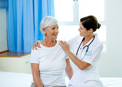 Buy stock photo Happy consultation, nurse and old woman in hospital room for advice, help and support at senior care clinic. Retirement caregiver, counselling and elderly patient with smile on bed with female doctor