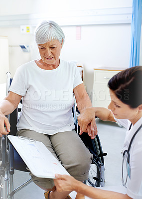 Buy stock photo Shot of a beautiful young female doctor discussing results with a senior patient