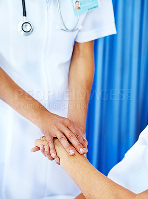 Buy stock photo Closeup of a doctor comforting her patient by holding her hand